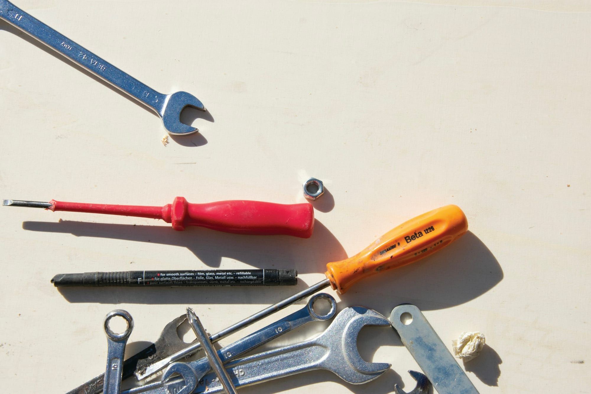Screwdrivers and wrenches laid out on a work surface