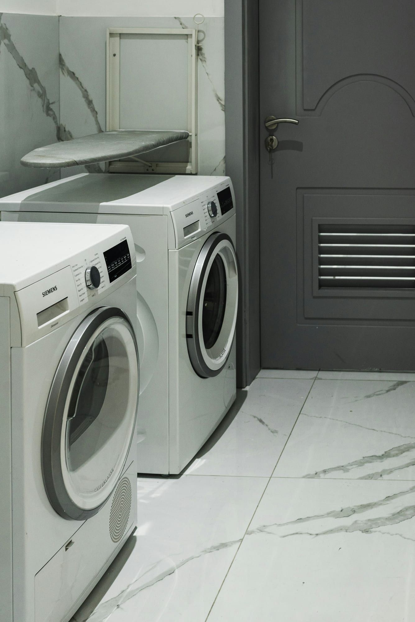 White front-load washer and dryer in a home laundry area